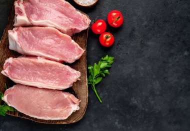 Tahtada çiğ et dilimleri, kişniş ve domatesli.