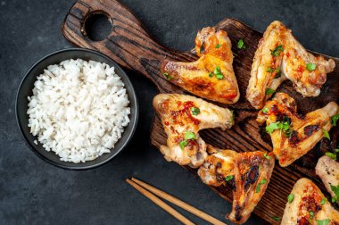 Kızarmış tavuk kanadı et ve pirinçli kase.