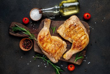 Tahta kesme tahtasında kızarmış tavuk bacağı.