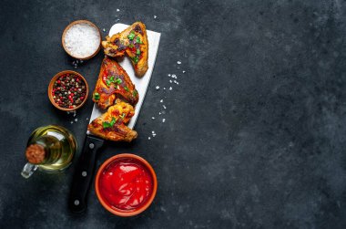 Kızarmış tavuk kanatlı Çin bıçağı et, ketçaplı kase, yağ ve tuzlu biber.