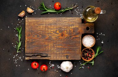 Tahta kesme manzarası ve baharatlı malzemeler, kırmızı domates, sarımsak ve yağ.