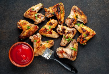 Kızarmış tavuk kanadı, kurutulmuş et, ketçap soslu kase ve fırça.