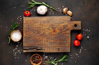 Koyu arkaplanda izole edilmiş ahşap tahta ve baharat malzemelerinin üst görünümü