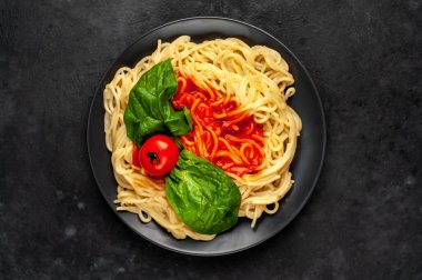 Domates ve fesleğen yapraklı lezzetli makarna.