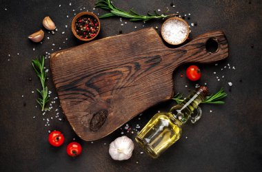 Tahta kesme manzarası ve baharatlı malzemeler, kırmızı domates, sarımsak ve yağ.