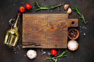 Tahta kesme manzarası ve baharatlı malzemeler, kırmızı domates, sarımsak ve yağ.