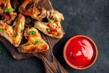 Kızarmış tavuk kanatlı ahşap tahta et, koriander ve ketçap soslu kase