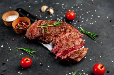 Baharatlı ızgara biftek ve arka planda bir bıçak.