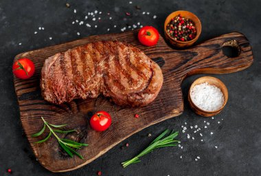 Baharatlı ızgara biftek, arka planda kesim tahtası.