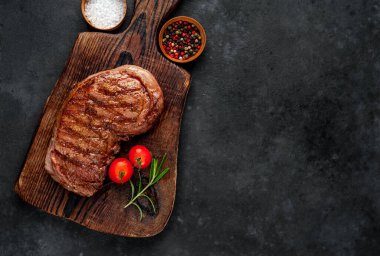 Baharatlı ızgara biftek, arka planda kesim tahtası.