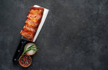 Mutfak baltasında domuz pirzolası ve siyah masada bitki, yakın görüş.