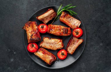 Domuz pirzolası ve domatesli siyah masa, yakın görüş. 