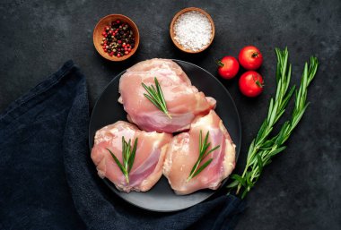 Tabakta çiğ tavuk butları, domates ve baharatlar, yakın görüş.