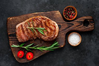 Baharatlı ızgara biftek, arka planda kesim tahtası.