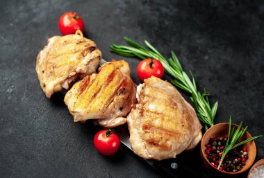 Çin satırı bıçağında domates ve baharatla pişirilmiş tavuk butları, yakın görüş. 