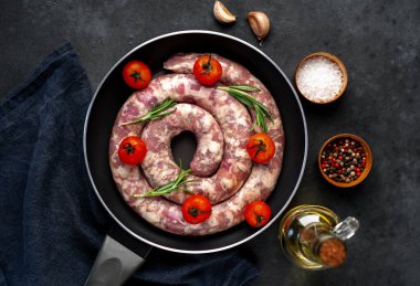 Kızartma tavasındaki malzemelerle çiğ sosis pişirmek.