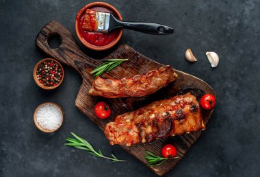 Domuz pirzolası ve domatesli ahşap kesim tahtası.