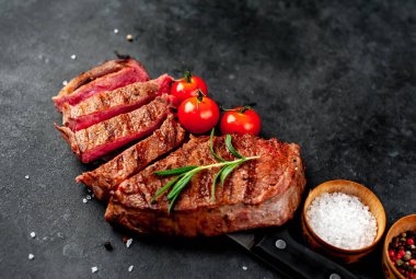 Baharatlı ızgara biftek ve arka planda bir bıçak.