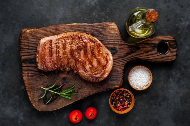 Baharatlı ızgara biftek, arka planda kesim tahtası.