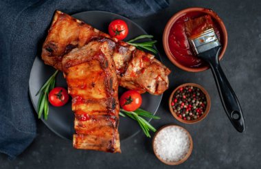 Domuz pirzolası ve domatesli siyah masa, yakın görüş. 