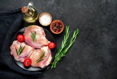 Tabakta çiğ tavuk butları, domates ve baharatlar, yakın görüş. 