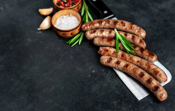 grilled sausages on kitchen ax with rosemary and garlic, barbecue concept