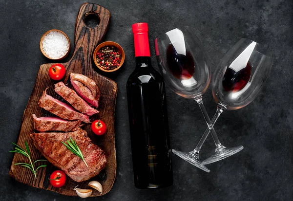牛のステーキを串焼きにしたものと赤ワインのボトル 石の背景のグラス — ストック写真
