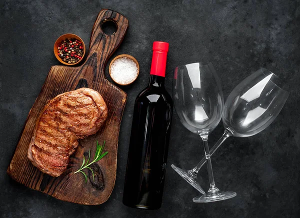 牛のステーキを串焼きにしたものと赤ワインのボトル 石の背景のグラス — ストック写真