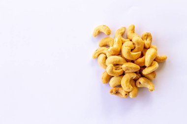 Birçok kavrulmuş tuzlu kaju fıstığı beyaz arka planda izole edilmiş.
