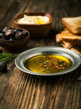 Ahşap bir sırt grubunda zeytinyağı, baharat, zeytin ve peynir