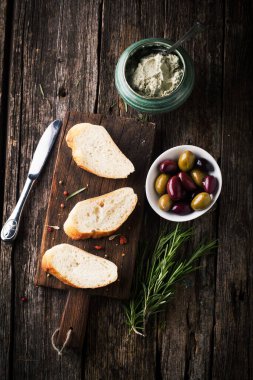 Ciabatta Ekmeği, ahşap bir arka planda peynir ezmesi ve biberiye.