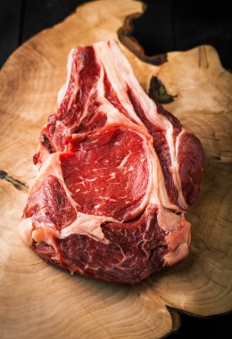 Tahta bir arka planda kesme tahtasındaki çiğ biftek.