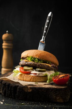 Koyu bir sırtta bıçak ve baharatlı leziz sığır etli burger.