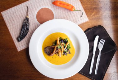 Sarı biber soslu ızgara ördek, tempura ve taze yeşil salata.