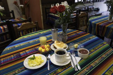 Kahve, tatlı, tereyağı, portakal suyu, tost ve taze meyveden oluşan kahvaltı.