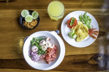 Ekvador karidesi cebiche kızarmış muz ve yer fıstığı ile servis edilir.