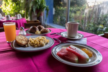 Tam kahvaltı. Bir fincan kahve, meyve, reçel, omlet, köfte, ekmek ve portakal suyu.