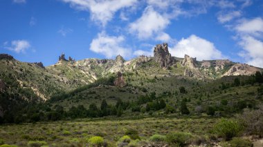 Kayalık tepeler dağı, mavi gökyüzü ve beyaz bulutlar.
