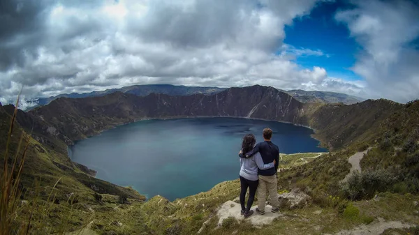 Quilotoaというクレーターの中のラグーンの風景を考えている観光客のカップル — ストック写真