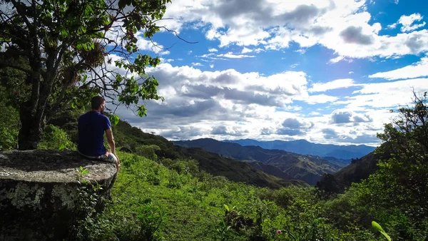 Mannen sitter på en klippa och tittar på ett ecuadorianskt vackert landskap. Panoramautsikt från Sierra — Stockfoto