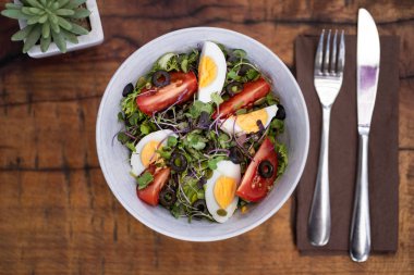 Taze sebze salatası. Çatal bıçaklı ve kaktüslü ahşap bir arka plan. Üst görünüm