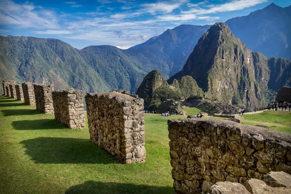 Sitio arqueológico Machu Picchu desde el interior. Grandes paredes hechas de piedras y algunos turistas se pueden ver — Foto de Stock