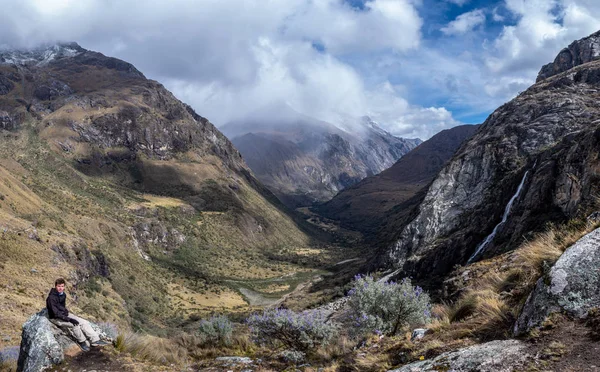 Un hombre sentado en una roca en un paisaje de montaña en la Cordillera Blanca, Perú — Foto de Stock
