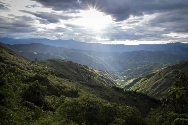 Panoramablick auf die ecuadorianische Sierra bei Sonnenuntergang. große Wolken, Berge, Sträucher und Bäume. — Stockfoto