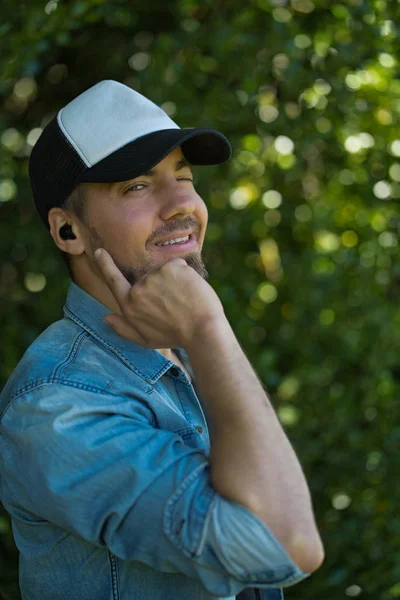 Blanc homme clin d'oeil, il écoute de la musique avec des écouteurs sans fil — Photo