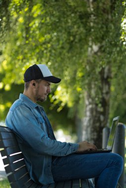 Kablosuz kulaklıklı bilgisayar kullanan beyaz bir adam.