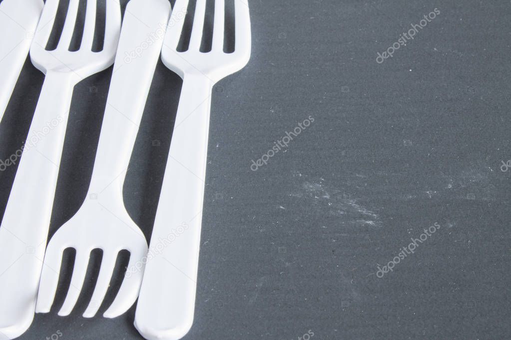 Plastic white forks on grey background