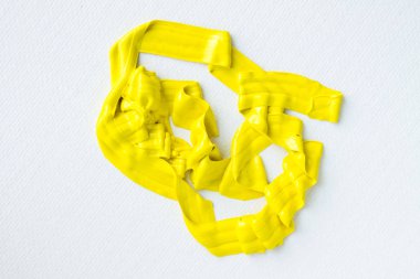 Beyaz bir tuvalde sarı bir boya lekesi.