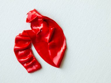 Beyaz astar bir tuvalin üzerinde parlak kırmızı bir yağ lekesi.