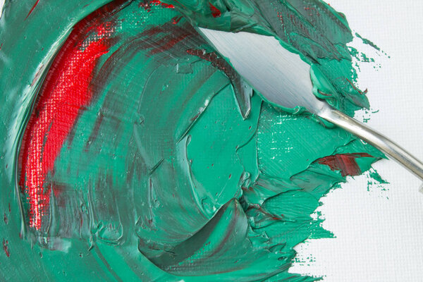 Mixing green and red paint on a white canvas